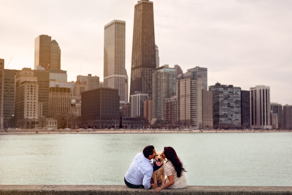 An engagement session for an engaged couple and a dog kissing at Olive Park in Chicago in the fall by a wedding photographer Mila Craila Photography