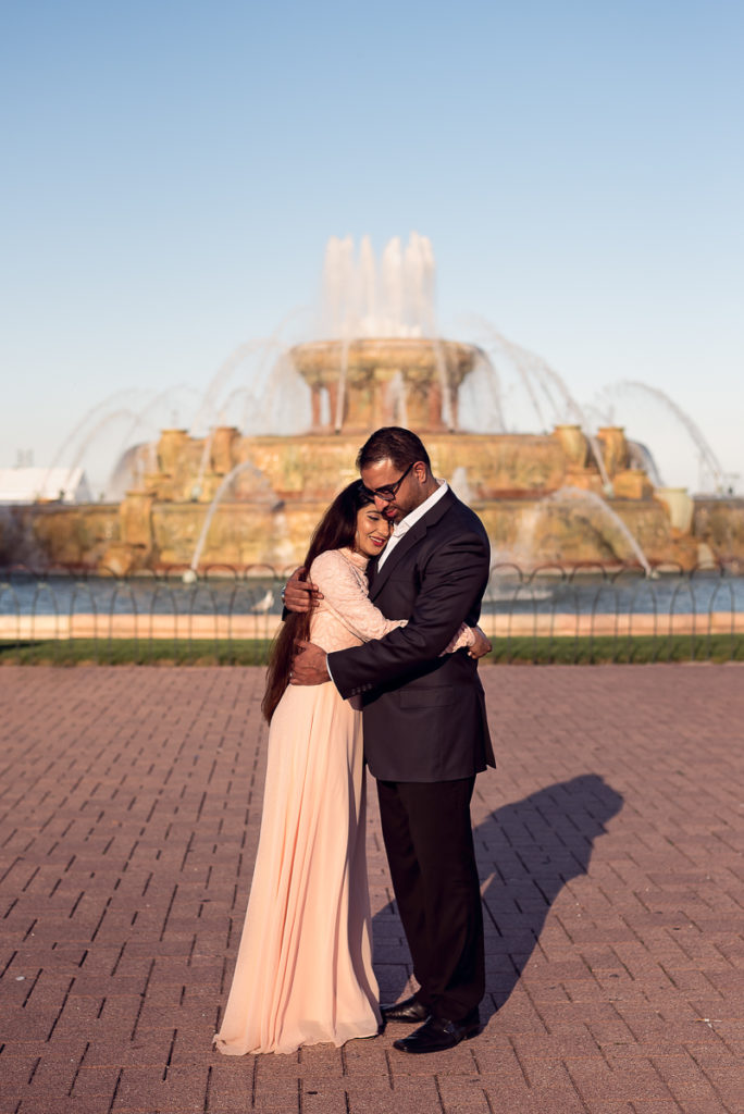 An engagement session for an engaged couple at the Buckingham Fountain in Chicago in the summer by a wedding photographer Mila Craila Photography