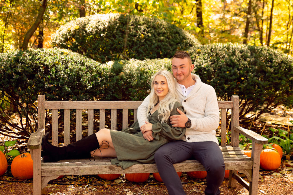 An engagement session for an engaged couple on the bench at Cantigny Park in Wheaton in the fall by a wedding photographer Mila Craila Photography