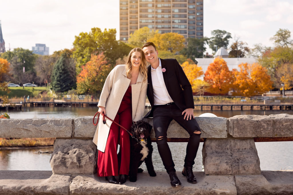 An engagement session for an engaged couple with a black dog in Lincoln Park in the fall by a wedding photographer Mila Craila Photography