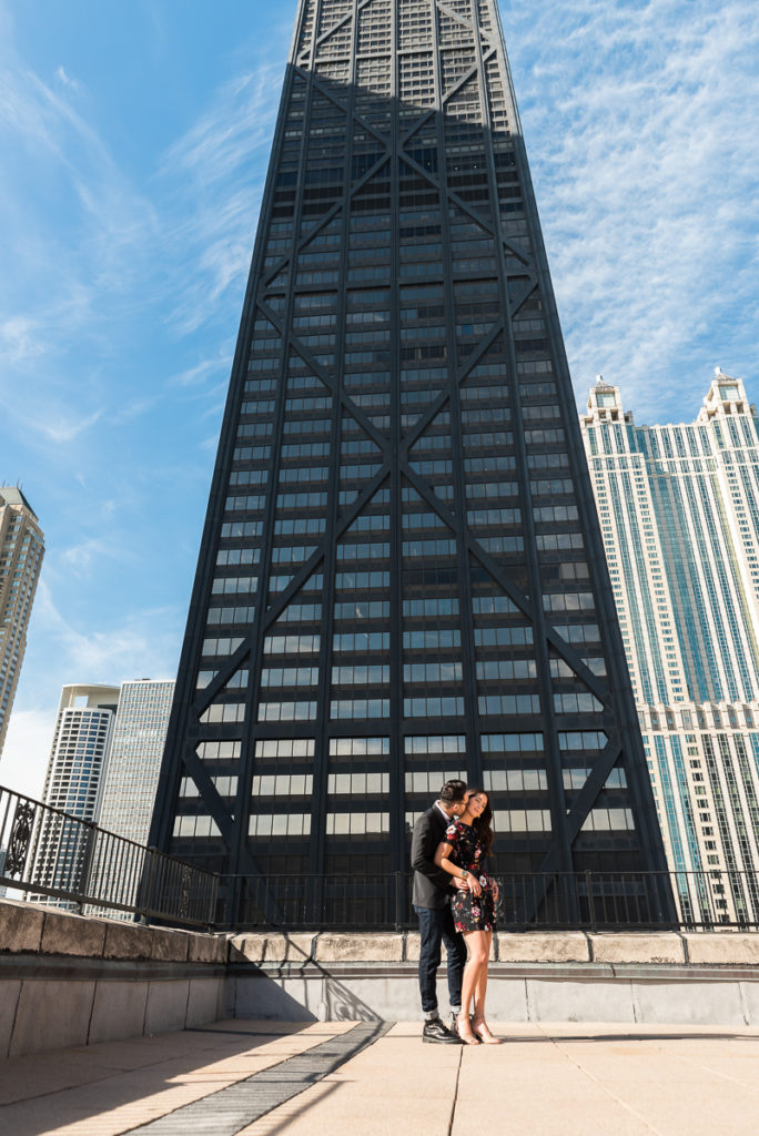 An engagement session for an engaged couple near Hancock Building in downtown Chicago in the fall by a wedding photographer Mila Craila Photography