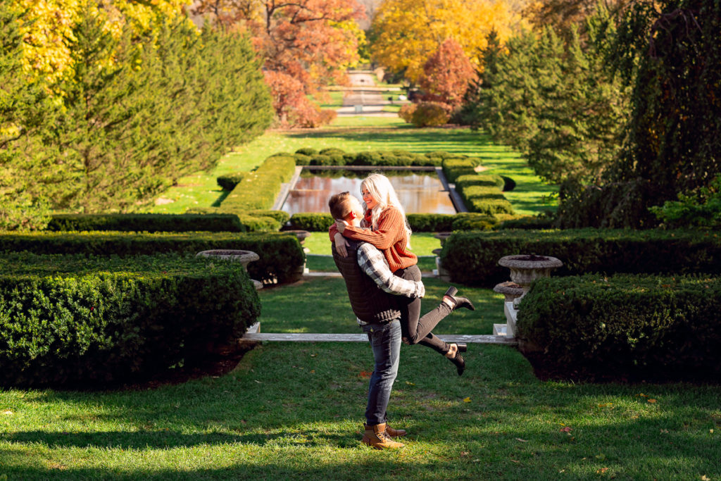 An engagement session for an engaged couple kissing at Cantigny Park in Wheaton in the fall by a wedding photographer Mila Craila Photography