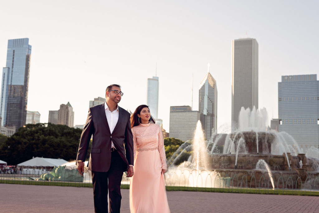 An engagement session for an engaged couple at the Buckingham Fountain in Chicago in the summer by a wedding photographer Mila Craila Photography