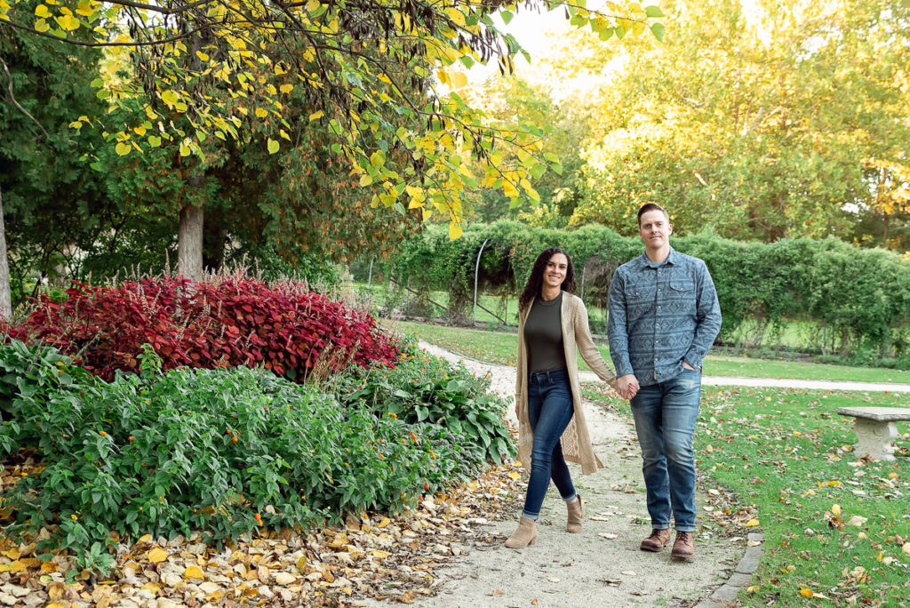 An engagement session for an engaged couple walking at Fabyan Forest Preserve in the fall by a wedding photographer Mila Craila Photography