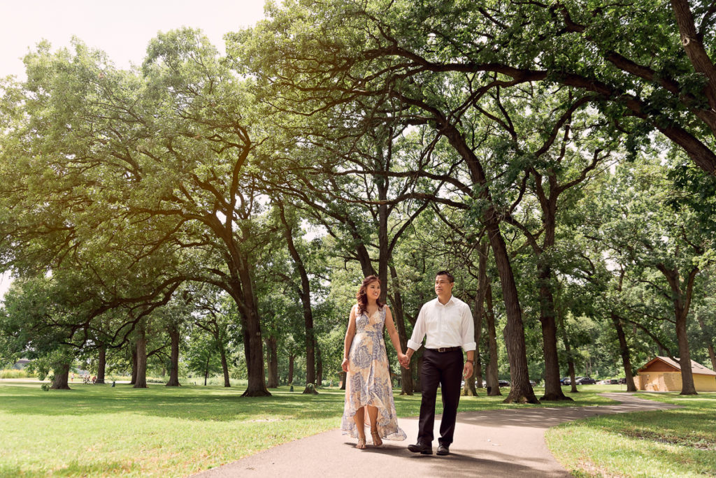 An engagement session for an engaged couple walking at Fabyan Forest Preserve in the summer by a wedding photographer Mila Craila Photography