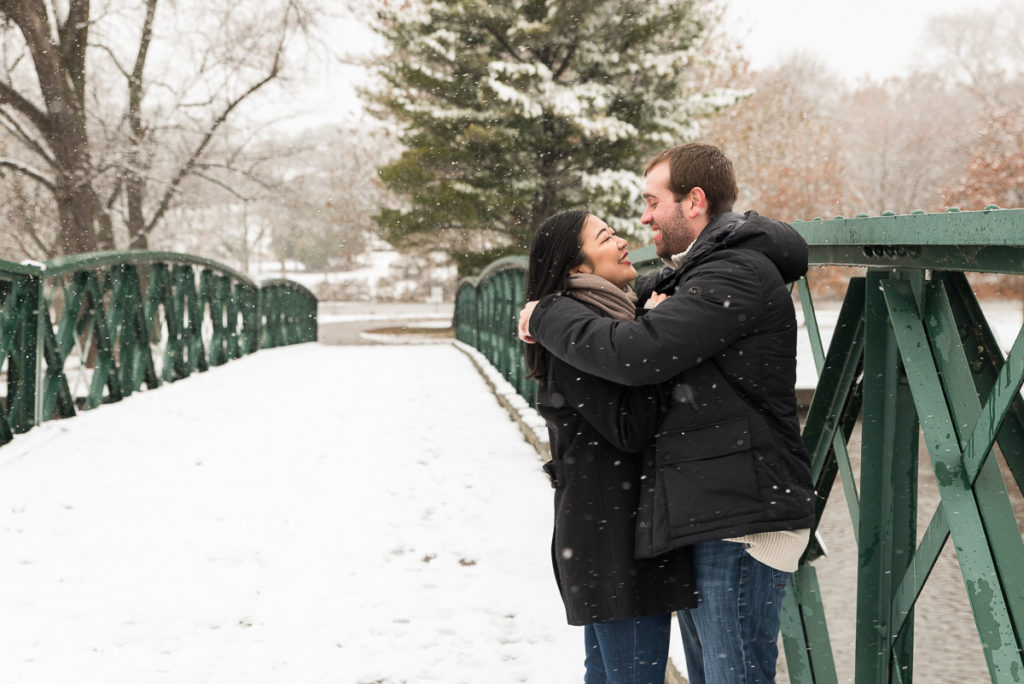 An engagement session for an engaged couple standing on a bridge at Fabyan Forest Preserve in the winter by a wedding photographer Mila Craila Photography