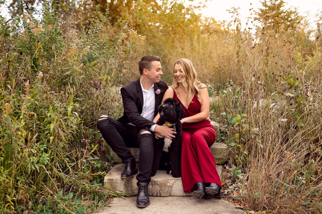 An engagement session for an engaged couple with a black dog in Lincoln Park in the fall by a wedding photographer Mila Craila Photography