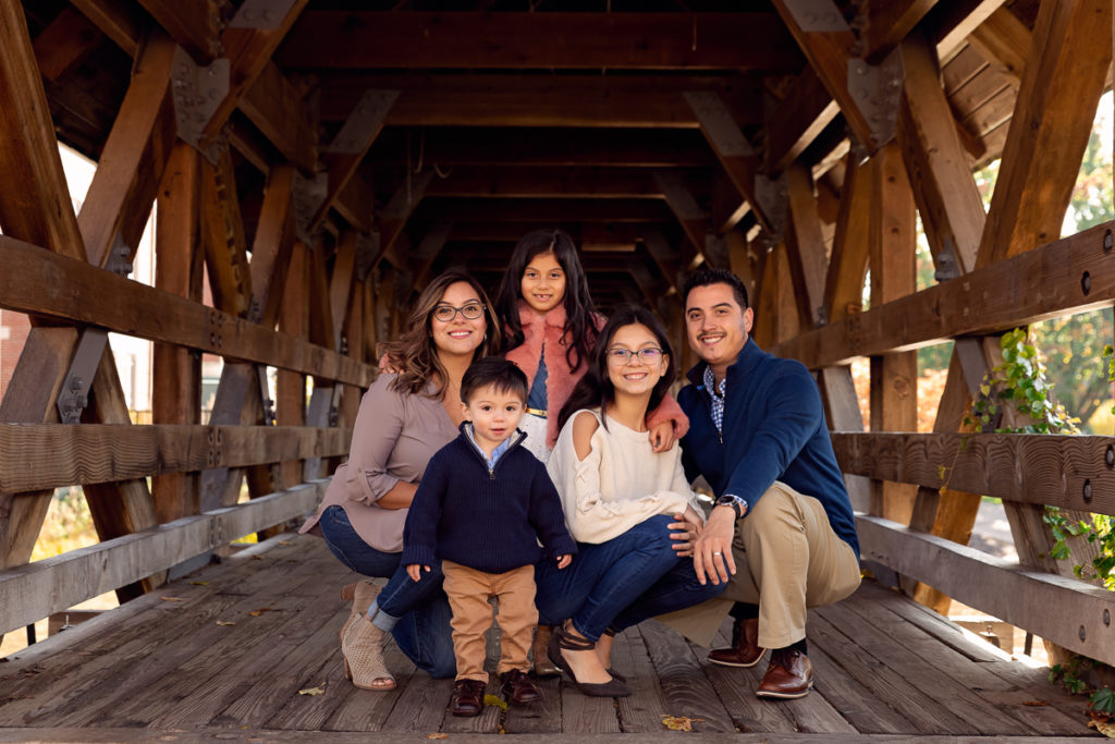 Family session for a family with three kids on the bridge on Naperville Riverwalk by family photographer Mila Craila Photography