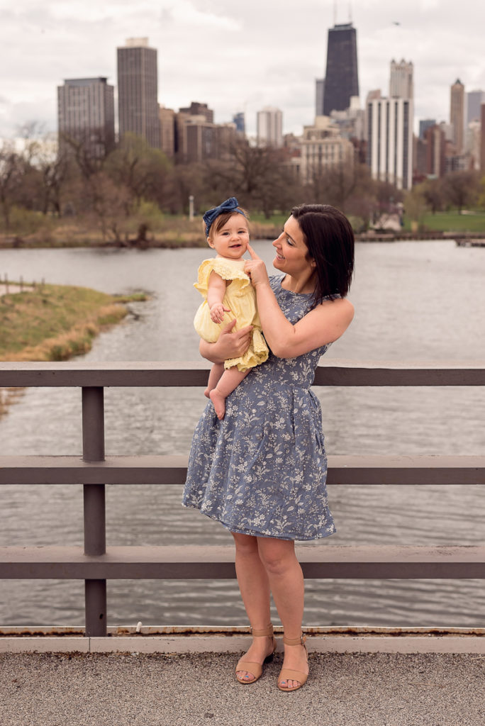 Family session for a mom with a toddler daughter on the bridge with a skyline view at Lincoln Park Zoo in Chicago in the summer by family photographer Mila Craila Photography