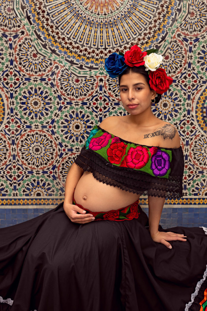 A maternity session for a pregnant woman in a traditional Mexican dress in Garfield Park Conservatory by a maternity photographer Mila Craila Photography