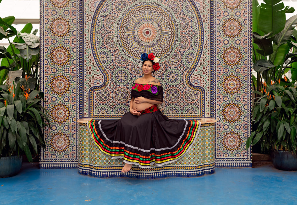 A maternity session for a pregnant woman in a traditional Mexican dress in Garfield Park Conservatory by a maternity photographer Mila Craila Photography