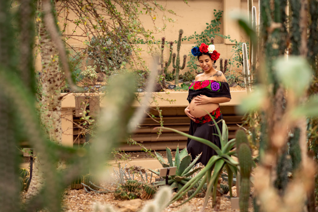 A maternity session for a pregnant woman in a traditional Mexican dress in desert of Garfield Park Conservatory by a maternity photographer Mila Craila Photography