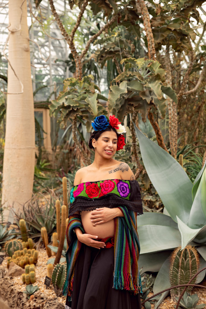 A maternity session for a pregnant woman in a traditional Mexican dress in desert of Garfield Park Conservatory by a maternity photographer Mila Craila Photography