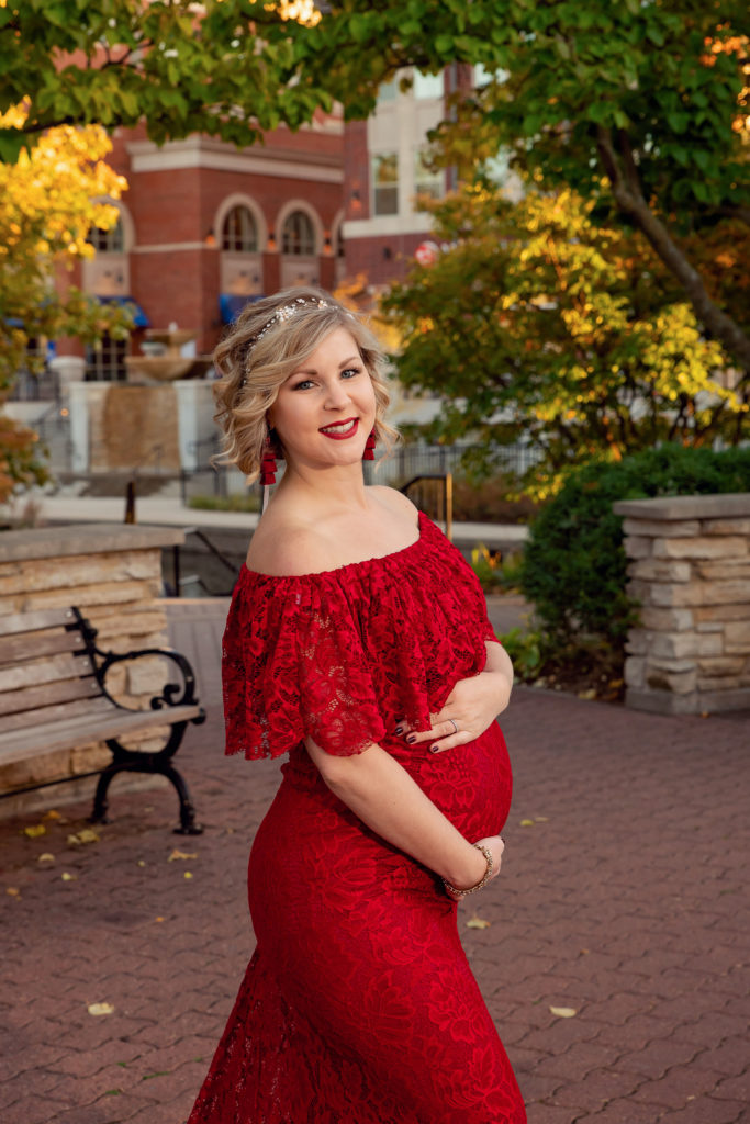 A maternity session for a pregnant woman in a red dress on Naperville Riverwalk by a maternity photographer Mila Craila Photography